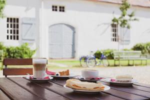 柏林Ferienwohnung Jagdschloss Grunewald的一张木桌,上面放着两盘食物和两杯咖啡