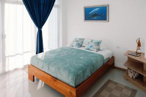 阿约拉港Modernas Habitaciones的一间卧室配有一张带蓝色床单的床和一扇窗户。