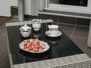 帕利克Apartmani Mikic的一张桌子,上面放着一盘食物和两个茶杯