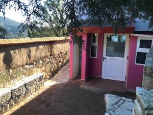 米内拉尔德尔蒙特Suite Campestre Real del Monte的粉红色门和石墙的房子