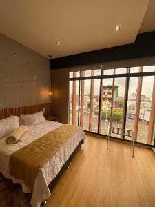 巴兰卡韦梅哈Hotel Casino GRAN AVENIDA的一间卧室设有一张大床和大窗户
