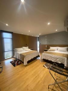 巴兰卡韦梅哈Hotel Casino GRAN AVENIDA的客房铺有木地板,配有两张床。