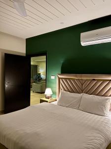 伊斯兰堡Serenity Corner 4 BHK的卧室配有白色的床和绿色的墙壁