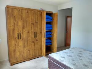 皮乌马Casa Temporada Monte H Piuma.的一间卧室配有带蓝色枕头的木制衣柜