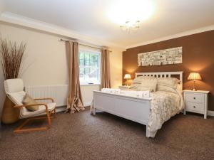 凯西克5 Ladstock Hall的卧室配有床、椅子和窗户。