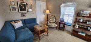 五月岬郡The Mason Cottage Downtown的客厅配有蓝色的沙发和椅子