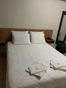 帕拉迪米纳斯勋爵大酒店的一张白色的床,上面有两条毛巾