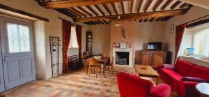 MonfrévilleLe domaine des Roseraies的客厅配有红色的沙发和桌子