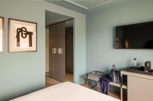 圣塞瓦斯蒂安Hotel Antik San Sebastián的一间卧室配有一张带镜子的床和一台电视