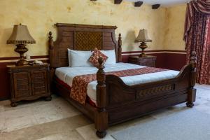 坎佩切海景酒店的一间卧室配有木床和2个床头柜