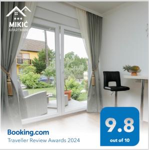 帕利克Apartmani Mikic的客房设有带椅子和书桌的窗户。