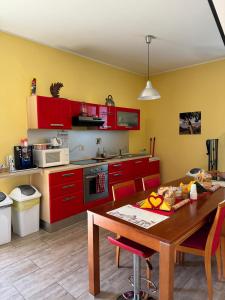 ZagaroloLA TERRAZZA SU ROMA的厨房配有红色橱柜和木桌