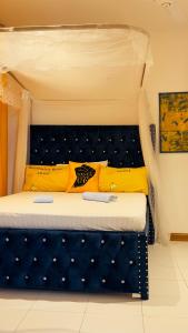 蒙巴萨The Pontoons Nyali A103的一张带蓝色床头板和黄色枕头的床