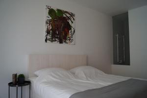 埃伦豪森Relax Residence Südsteiermark的卧室配有一张白色床,墙上挂有绘画作品