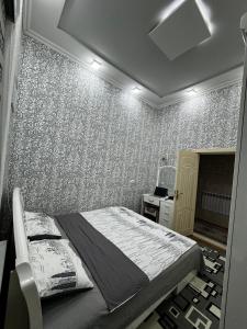 撒马尔罕4х комнатная квартира Дом的一间卧室配有床和壁纸墙