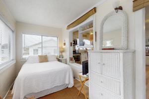 拉古纳海滩Linda's Cozy Cottage "C"的白色卧室配有床和镜子