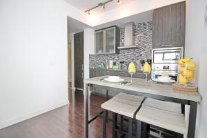 多伦多Presidential 2+1BR Condo, Entertainment District (Downtown) w/ CN Tower View, Balcony, Pool & Hot Tub的一间厨房,里面配有桌椅