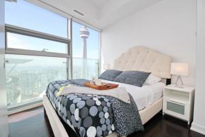 多伦多Presidential 2+1BR Condo, Entertainment District (Downtown) w/ CN Tower View, Balcony, Pool & Hot Tub的一间卧室设有一张床和一个大窗户