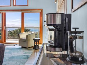 蒂拉穆克Shoreline Solace: Ocean View Townhouse Tillamook的窗户客房内的柜台上的咖啡壶