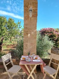 托雷圣乔万尼乌Villa Troisio的一张桌子,两把椅子,一张桌子,上面有食物