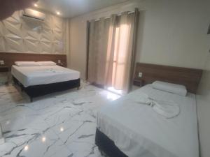 里奥克拉鲁Hotel Rio Claro的酒店客房带两张床,铺有大理石地板。