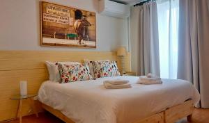 蓬塔德尔加达THE HOLY COW - Hostel & Suites的一间卧室配有带毛巾的床