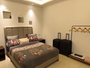 布拉柴维尔SYN - Mpila的一间卧室配有一张床和一个行李箱