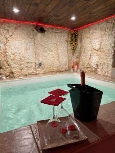 奥斯图尼Tama67 suite的游泳池提供一瓶葡萄酒和酒杯