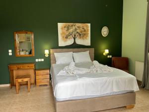 萨莫色雷斯Akrotiri studios的一间卧室设有一张大床和绿色的墙壁
