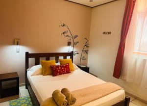 图里亚尔瓦Casa de Lis Hotel & Tourist Info Centre的一间卧室配有黄色和红色枕头的床