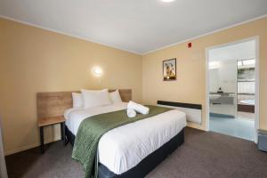 罗托鲁瓦芬顿科特汽车旅馆的一间带大床的卧室和一间浴室