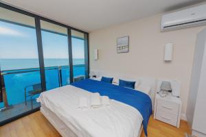 巴统Orbi City Sea View的卧室配有蓝色和白色的床和大窗户
