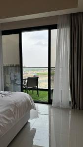 阿吉曼شقة فندقية ALzorah Ajman - الزوراء عجمان的一间卧室设有一张床和一个大型玻璃窗
