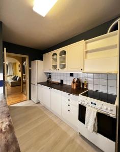 奥勒松Luxury Service Apartment by Chanya的厨房配有白色橱柜和黑色台面