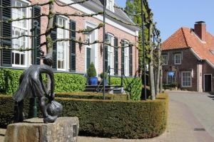 奥特马瑟姆Hotel Van der Maas的女郎在房子前面的立柱上的雕像