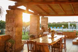 乌真托Ugento Country Cottage - Villa con Piscina的庭院配有木桌和椅子