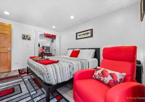 HuntleyHarmony Inn, Huntley Illinois的一间卧室配有一张床和一张红色椅子
