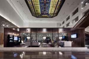 蒙特雷Wyndham Monterrey Ambassador Centro的大堂设有大型彩色玻璃天花板和客厅。