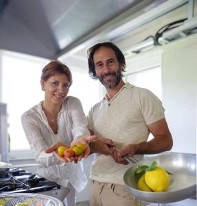 AglièAgrirelais La Bolla的站在厨房里拿着水果的男人和女人