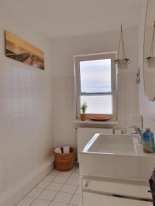 罗斯托克Charmante Maisonnette-Dachgeschosswohnung in zentraler Lage的白色的浴室设有水槽和窗户。