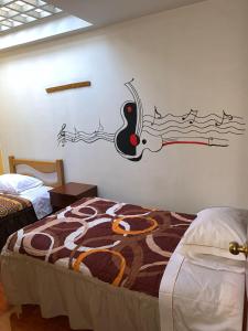 阿亚库乔Hospedaje Luciano的卧室配有一张床上,墙上挂着鸟