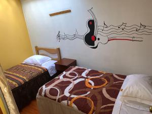 阿亚库乔Hospedaje Luciano的一间设有两张床的客房,墙上挂着一幅画
