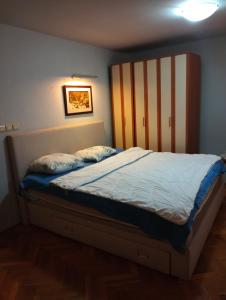 波德戈里察Hostel Lejla的卧室内的一张带木制床头板的床