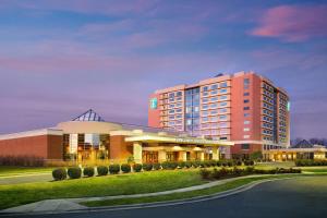 康科德Embassy Suites by Hilton Charlotte Concord Golf Resort & Spa的一座大型酒店,前面有一座建筑