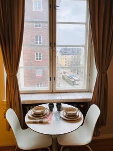 赫尔辛基Your Chic Vibrant Airbnb的窗前的一张桌子和两把椅子