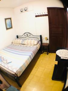 圣玛尔塔AptoPuntoCentro Santa Marta的一间小卧室,配有一张床和一扇门