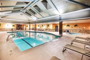 塔尔萨图尔萨市中心希尔顿逸林酒店的一座带长椅的大楼内的大型游泳池