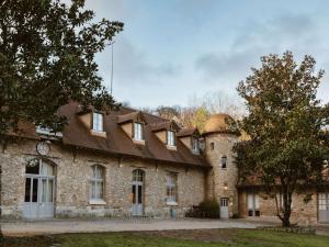 Cernay-la-Ville德沃塞尔奈修道院酒店的屋顶上有一个钟的旧砖砌建筑