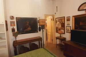 博洛尼亚B&B Fuori Dai Coppi - Bologna的客厅配有壁画和电视