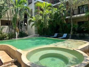 图卢姆Casa Tulum Hotel的一座大楼内带热水浴池的游泳池